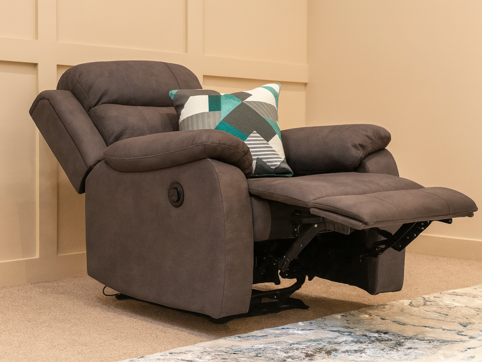 Brown recliner chair with a patterned pillow on a beige carpet